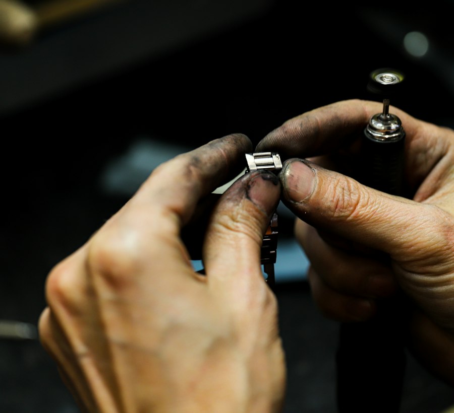 Hands setting a small stone into a metal setting